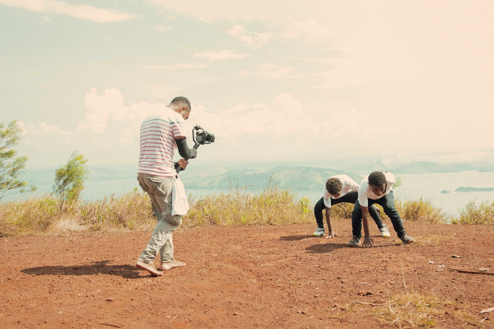 a group of people standing on top of a dirt field