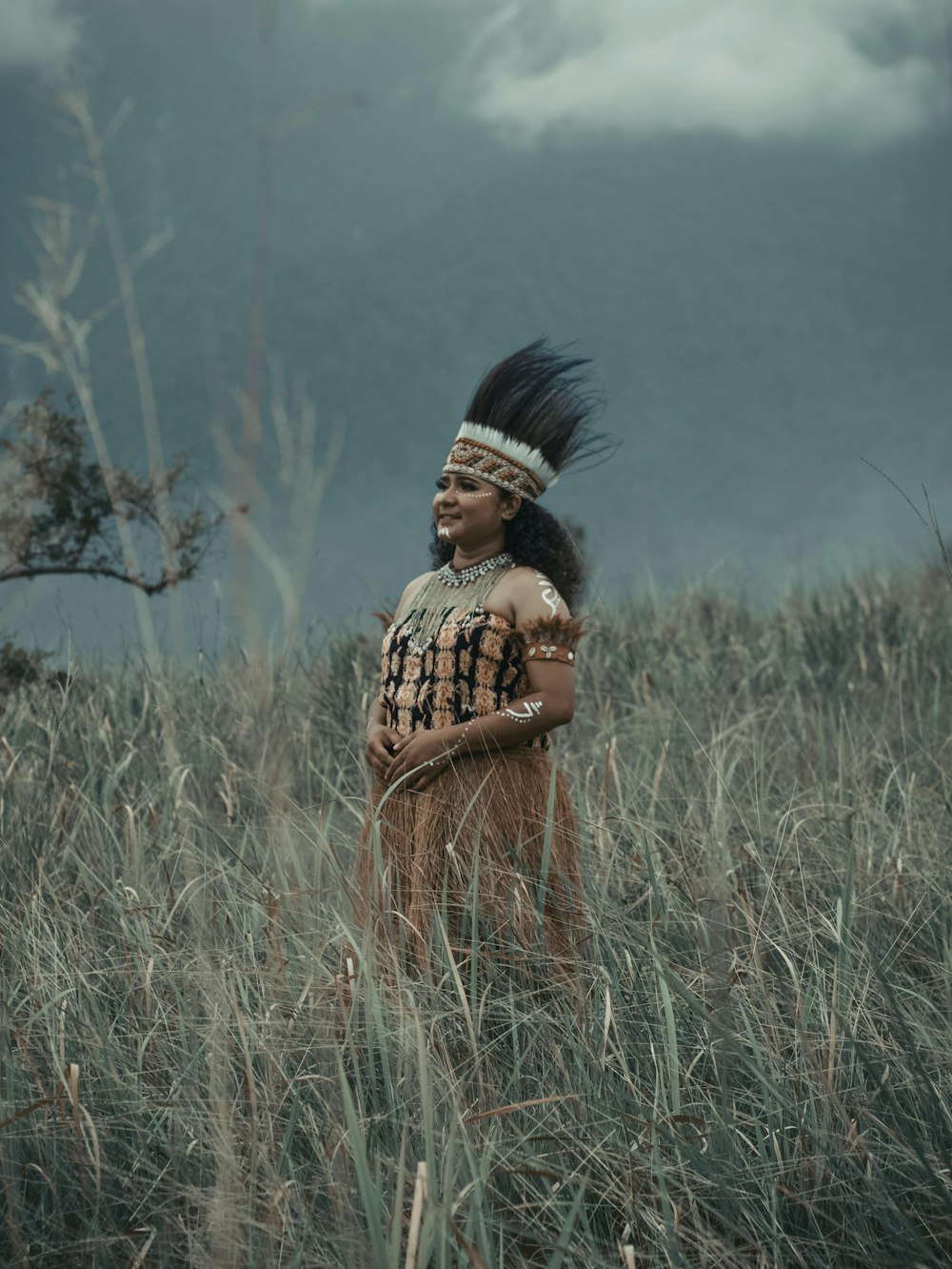 a native american woman standing in a field