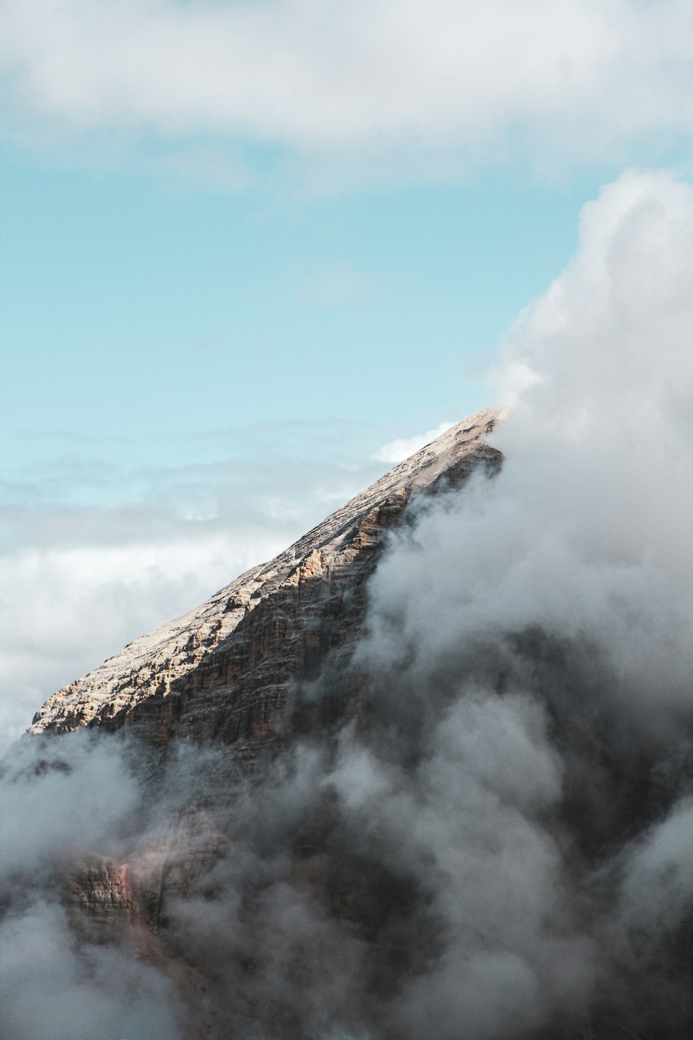 a mountain covered in clouds with a sky background