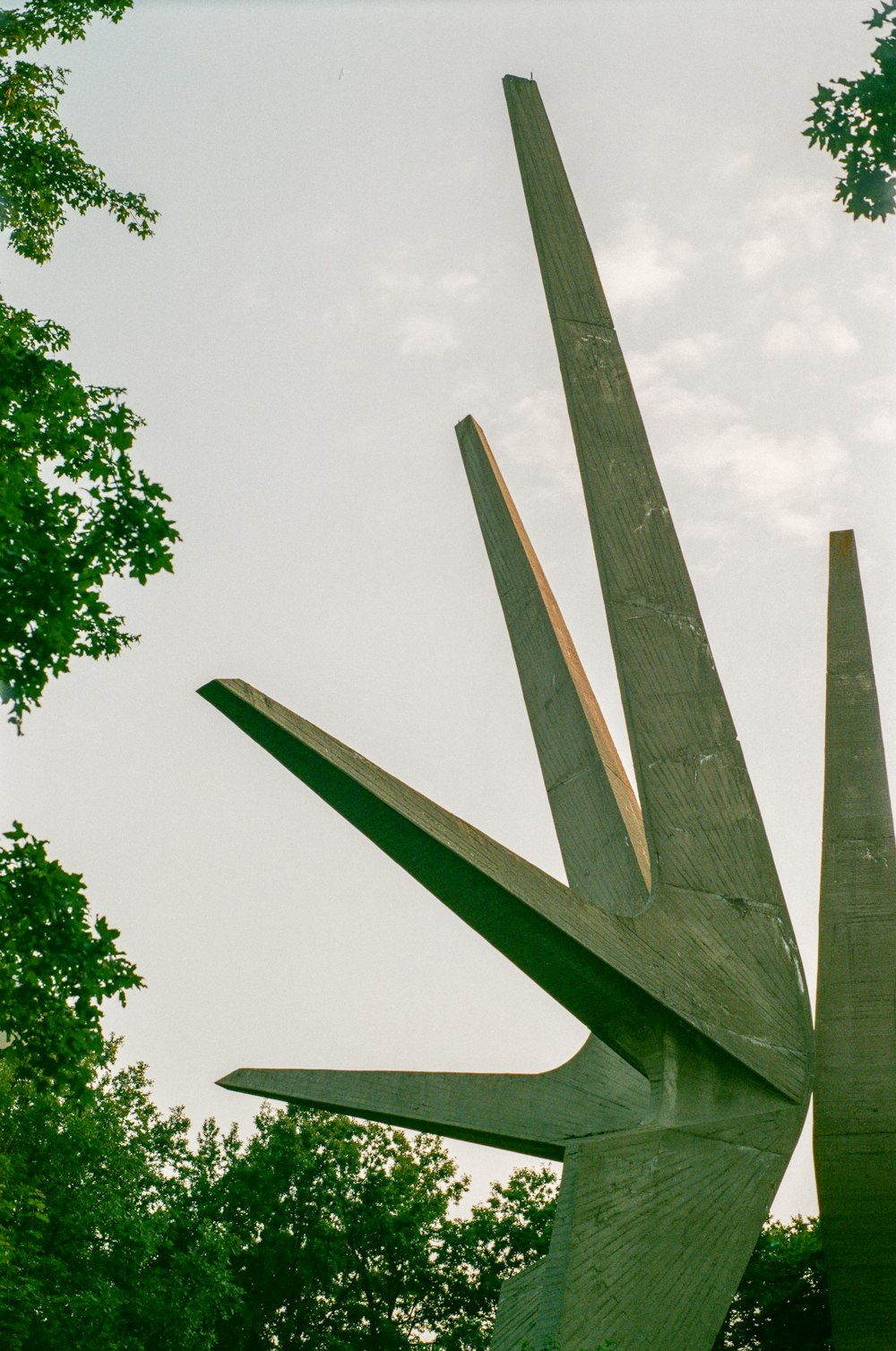 Una scultura di un paio di forbici con alberi sullo sfondo