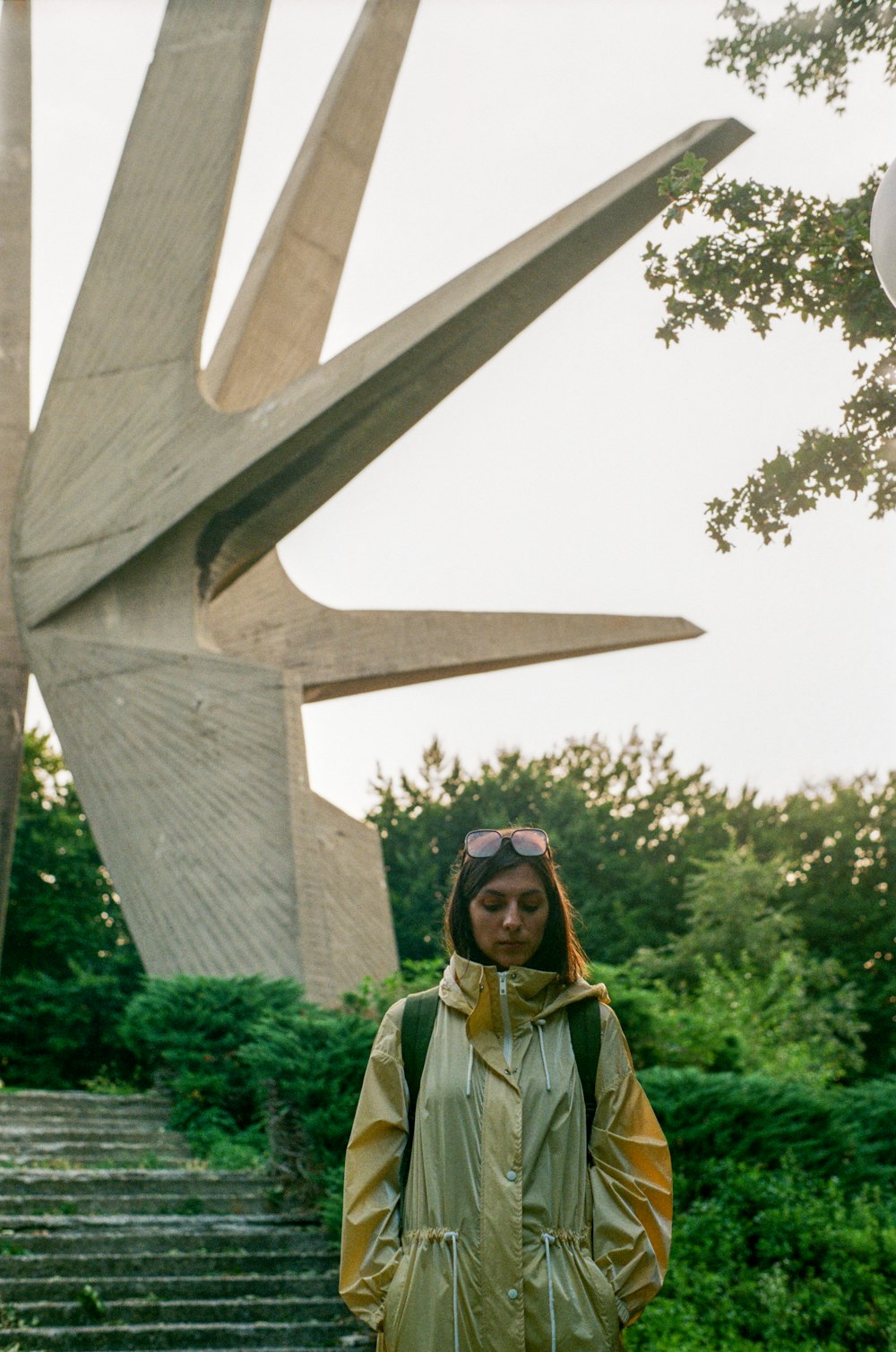 Una mujer parada frente a una gran escultura