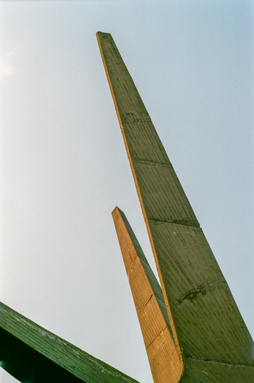 a view of the top of a sailboat against a blue sky