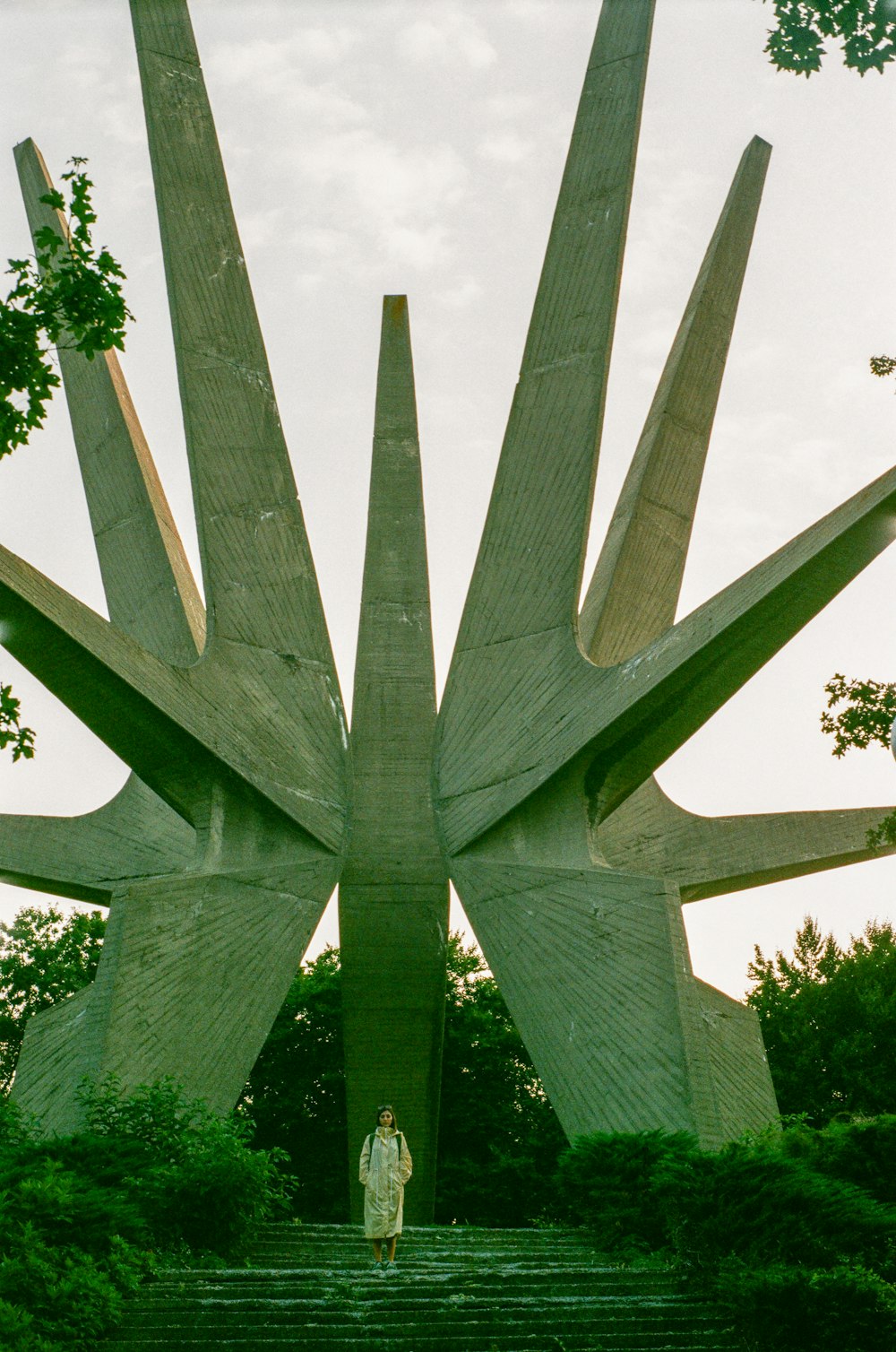 a woman is standing in front of a sculpture