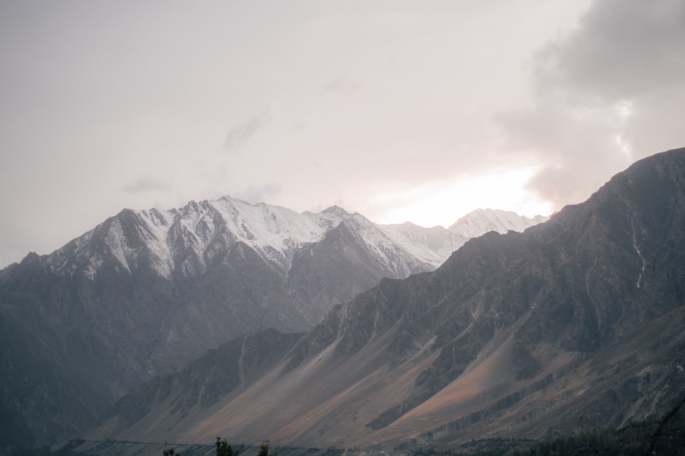 the mountains are covered in snow and clouds