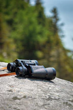 a pair of binoculars sitting on top of a rock