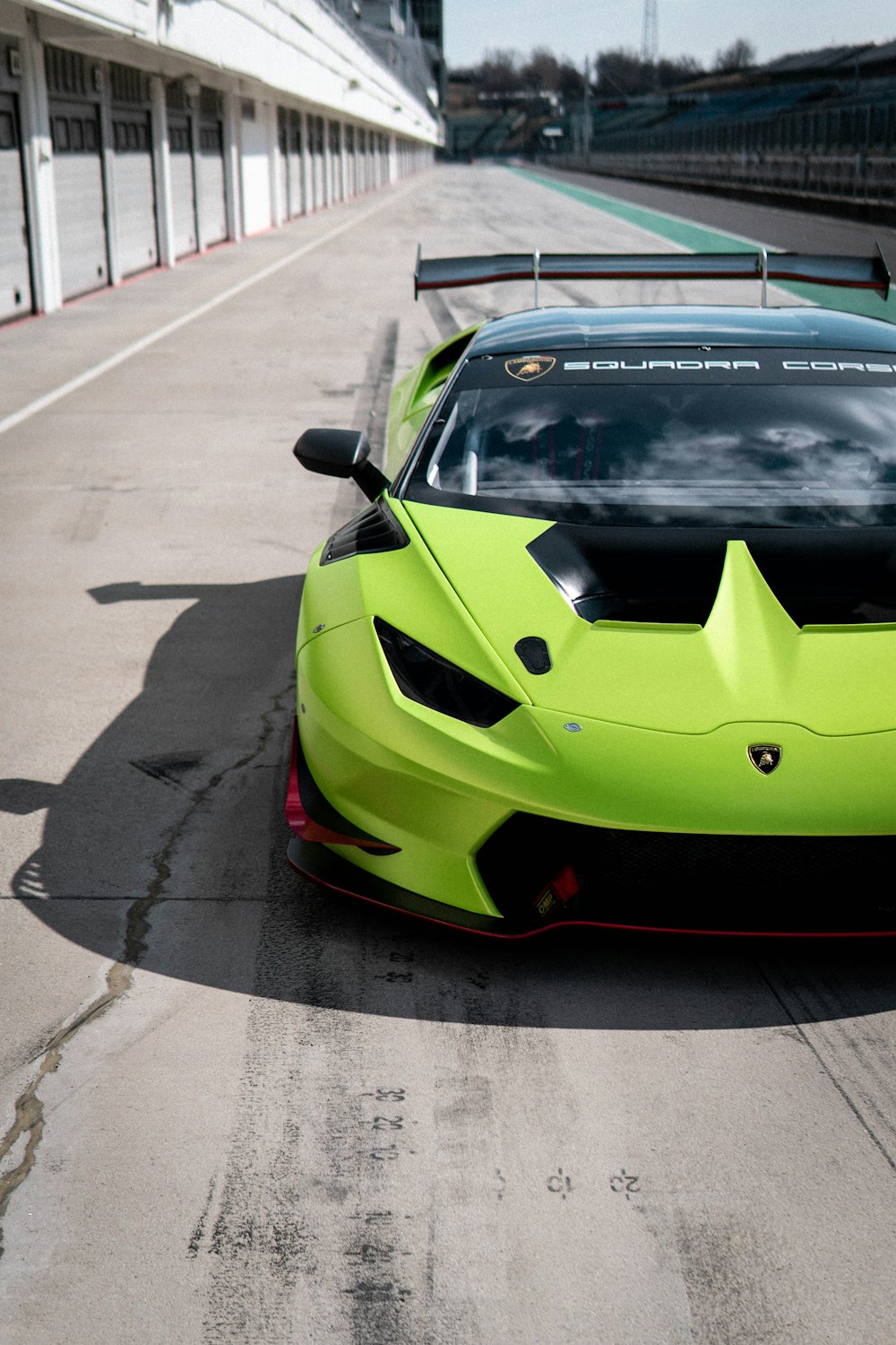 a green sports car driving down a race track