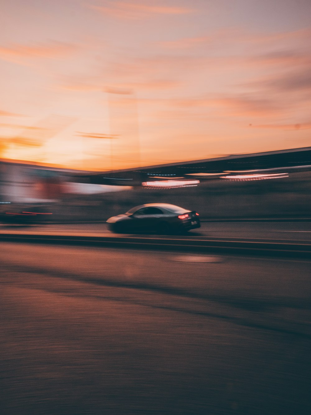 a car driving down a road at sunset