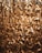 A dense cluster of translucent, intertwined acrylic chains with a golden hue, creating an intricate and luxurious texture. The light shines through them, adding a warm, glowing effect.