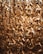 A dense cluster of translucent, intertwined acrylic chains with a golden hue, creating an intricate and luxurious texture. The light shines through them, adding a warm, glowing effect.