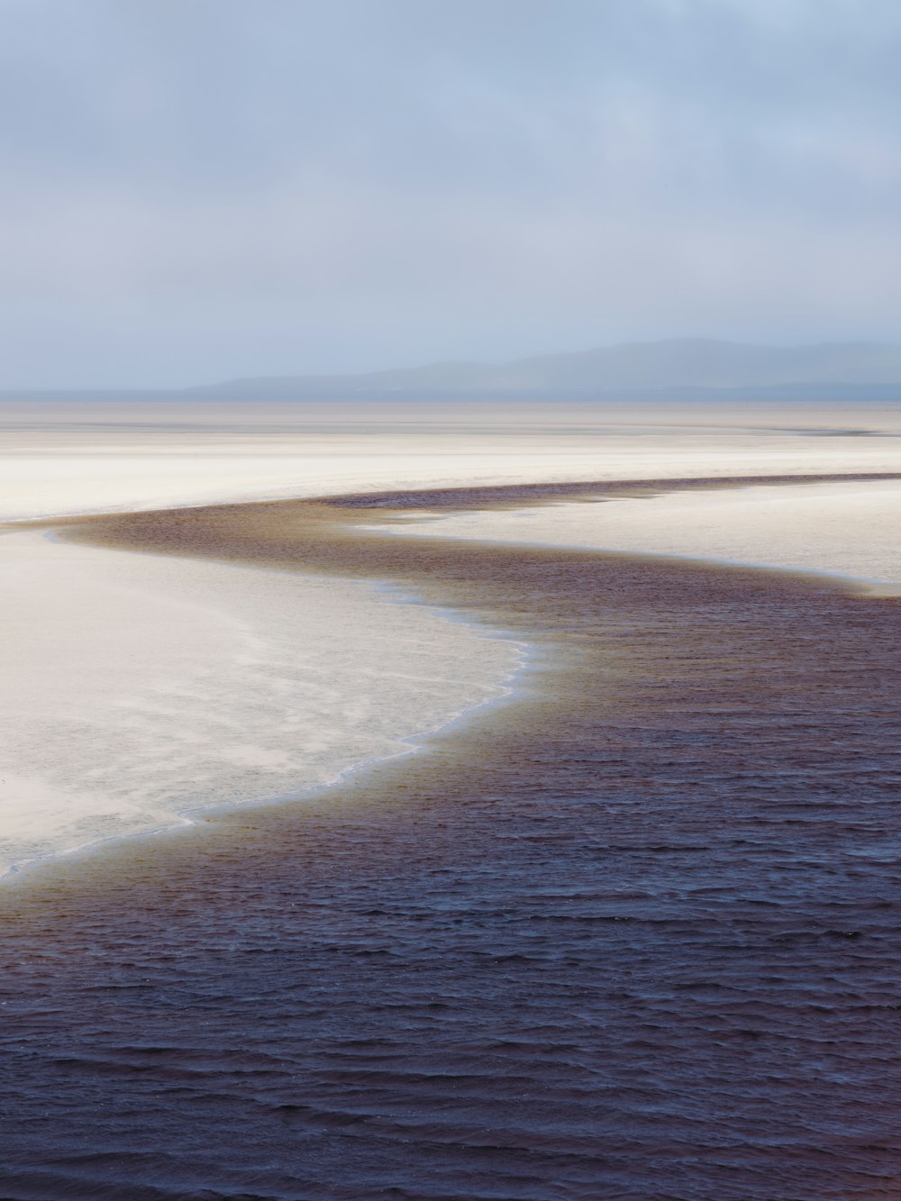 a large body of water sitting under a cloudy sky