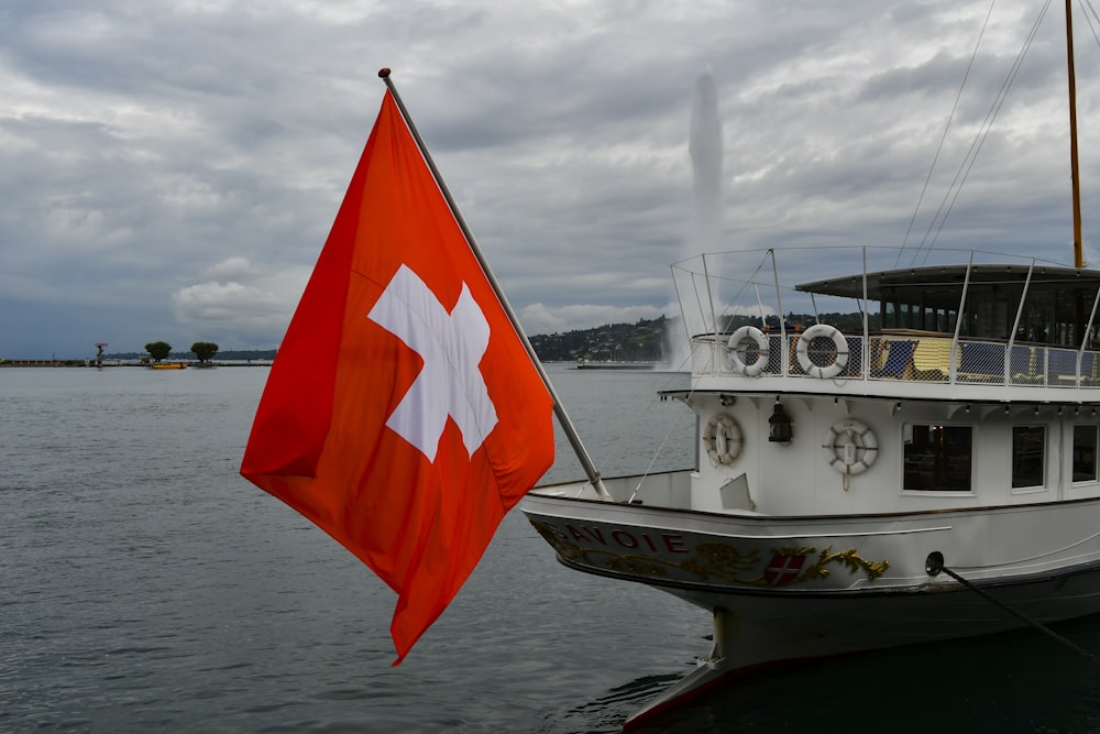 a large white boat with a red and white flag