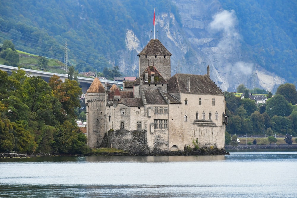 a castle sitting on top of a lake surrounded by mountains