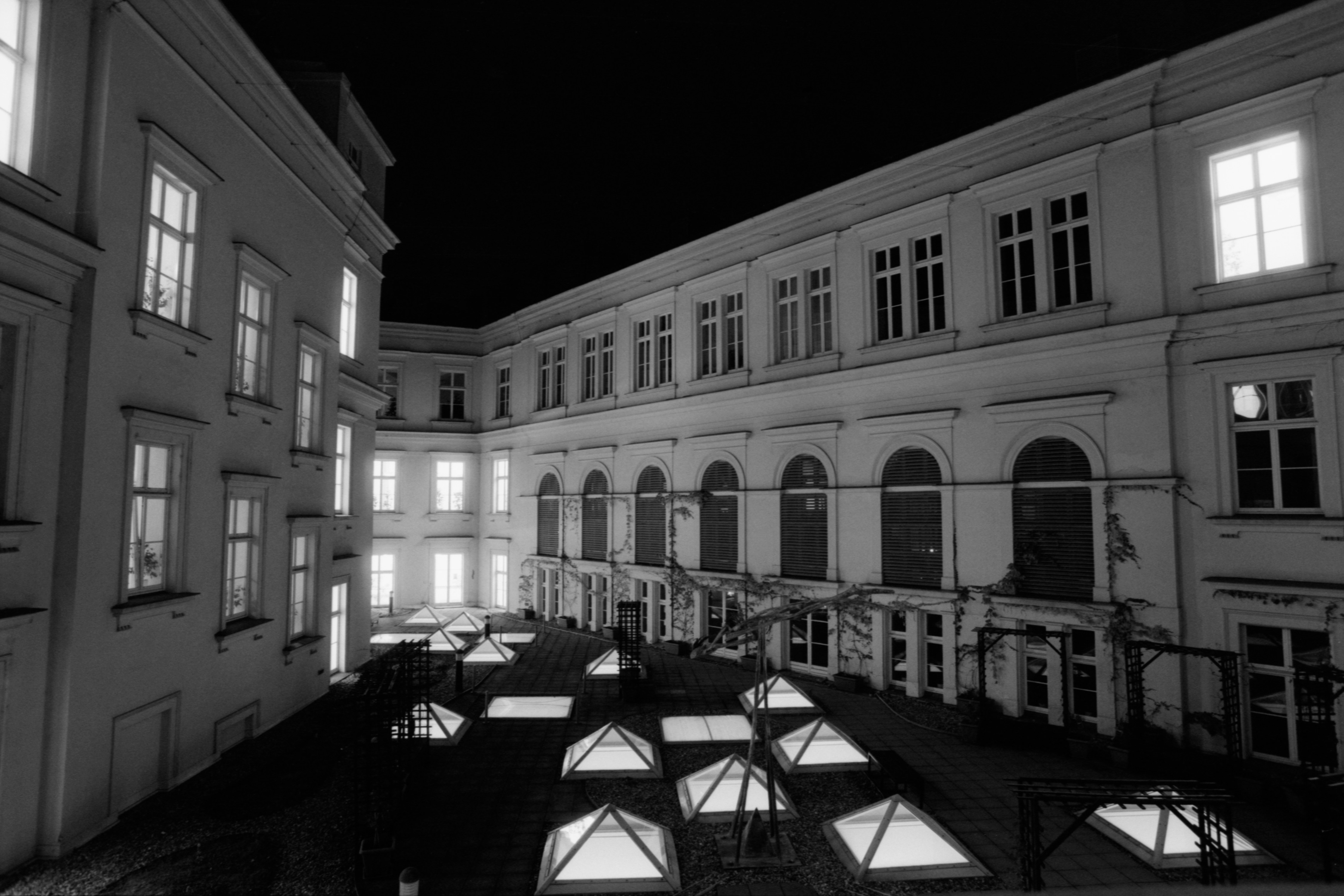 a black and white photo of a courtyard at night