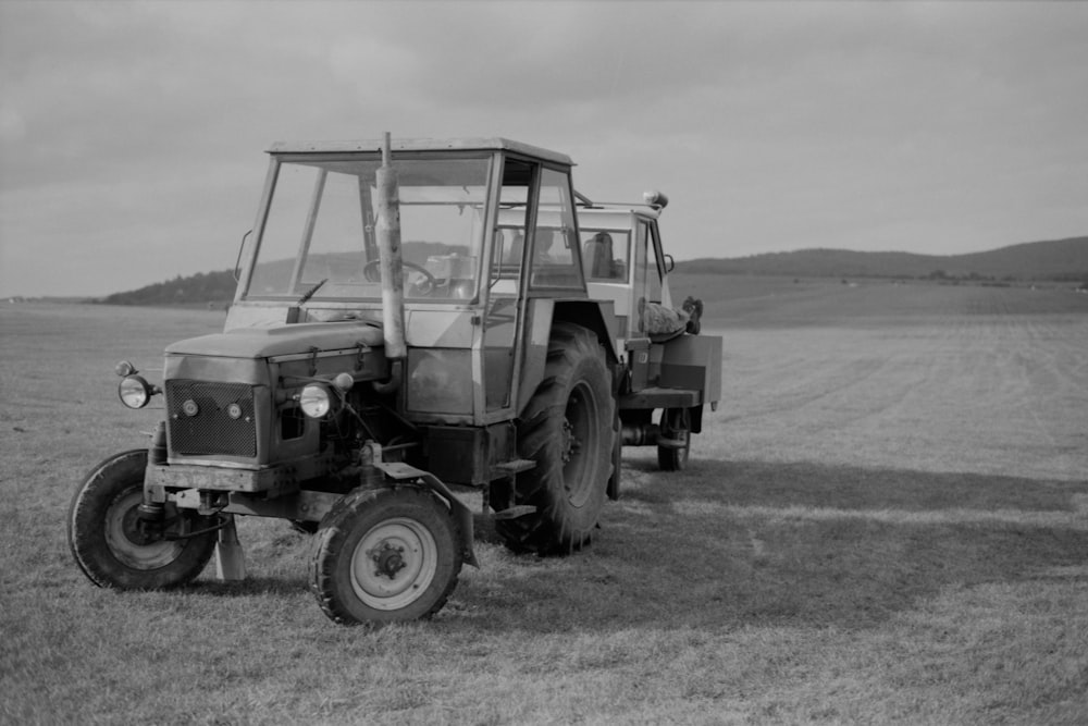 a black and white photo of a tractor in a field
