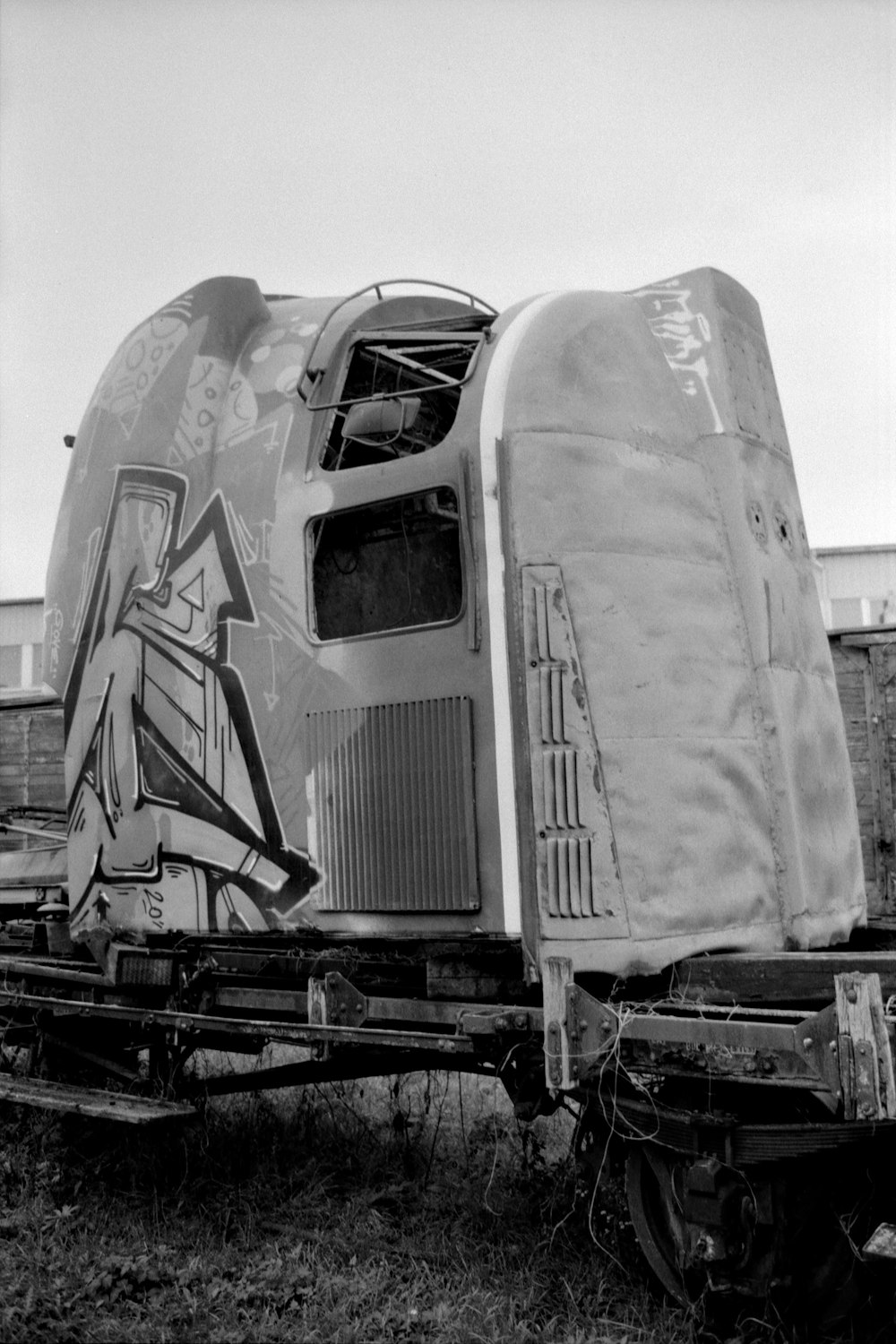 a black and white photo of a train car with graffiti on it