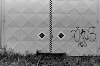 a black and white photo of graffiti on a wall