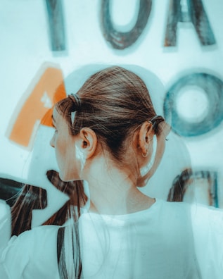 a woman with a ponytail standing in front of a sign