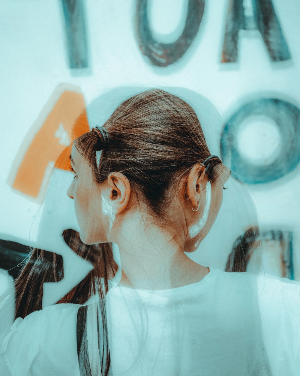 a woman with a ponytail standing in front of a sign