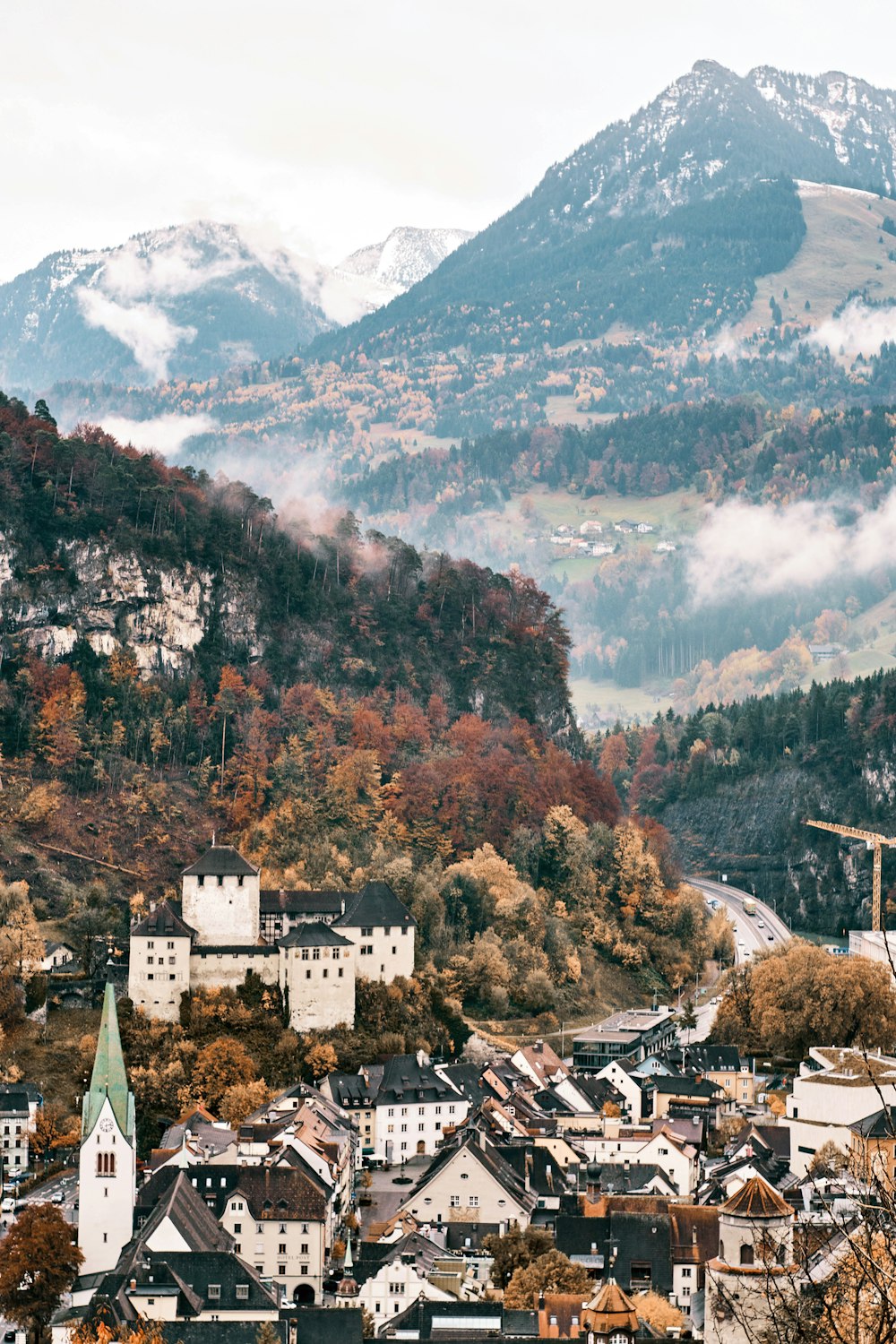 a scenic view of a town with mountains in the background