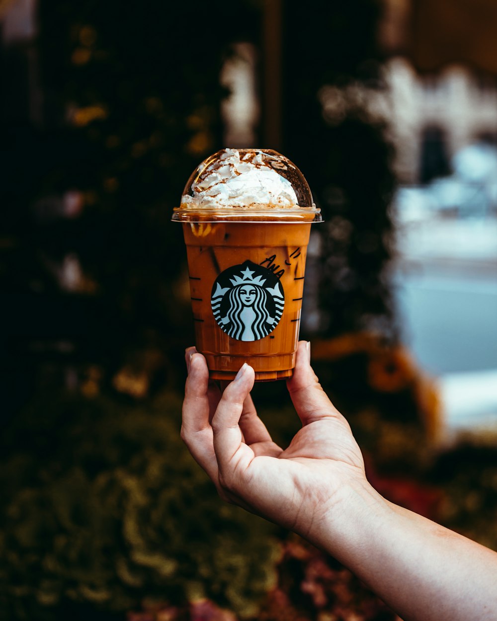 a person holding up a cup of coffee