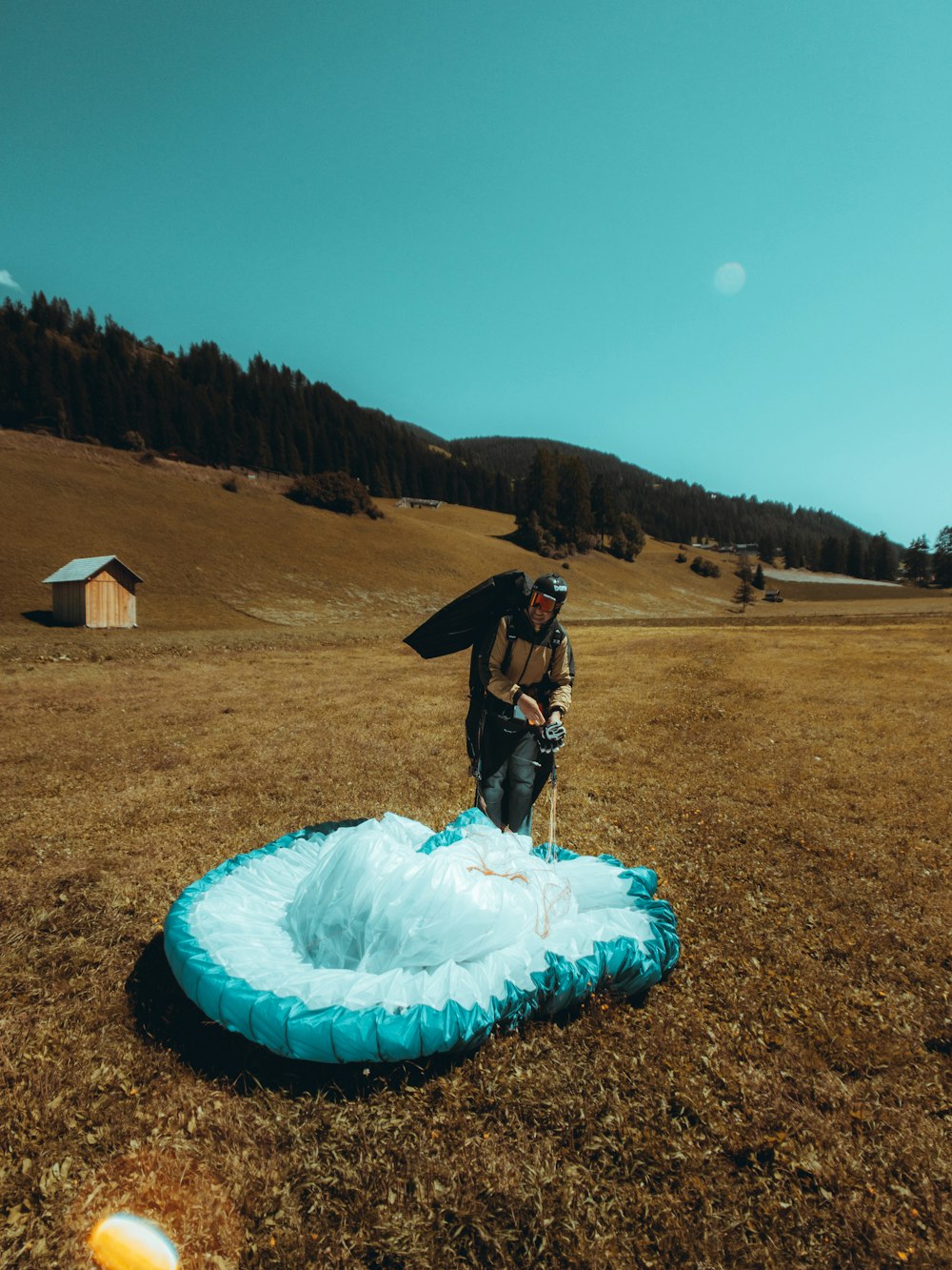 a man standing in a field next to a blue frisbee