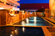 Swimming pool illuminated by color-changing smart lights under a starry night.