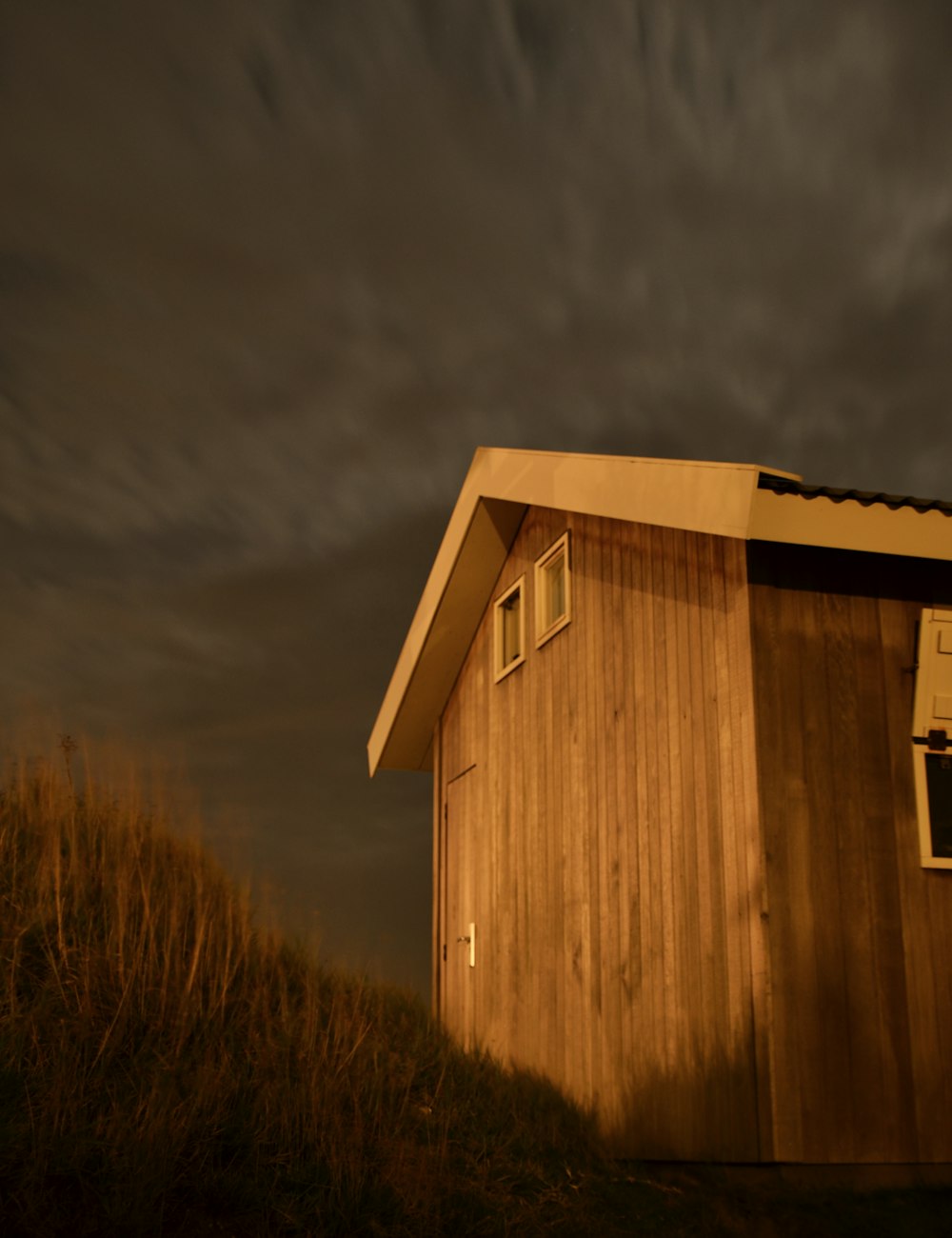 Un piccolo edificio di legno seduto sulla cima di una collina