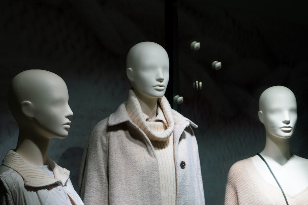 a group of mannequins wearing coats and scarves