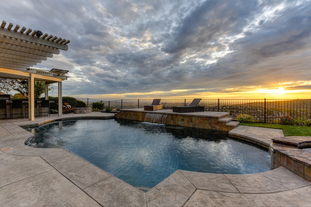 a backyard with a swimming pool and patio furniture