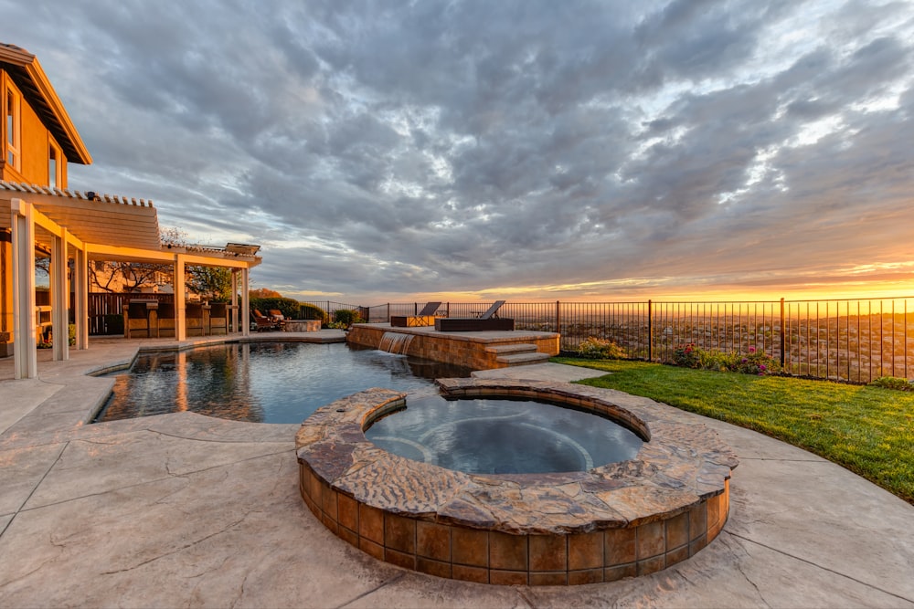 a hot tub sitting on top of a patio next to a swimming pool