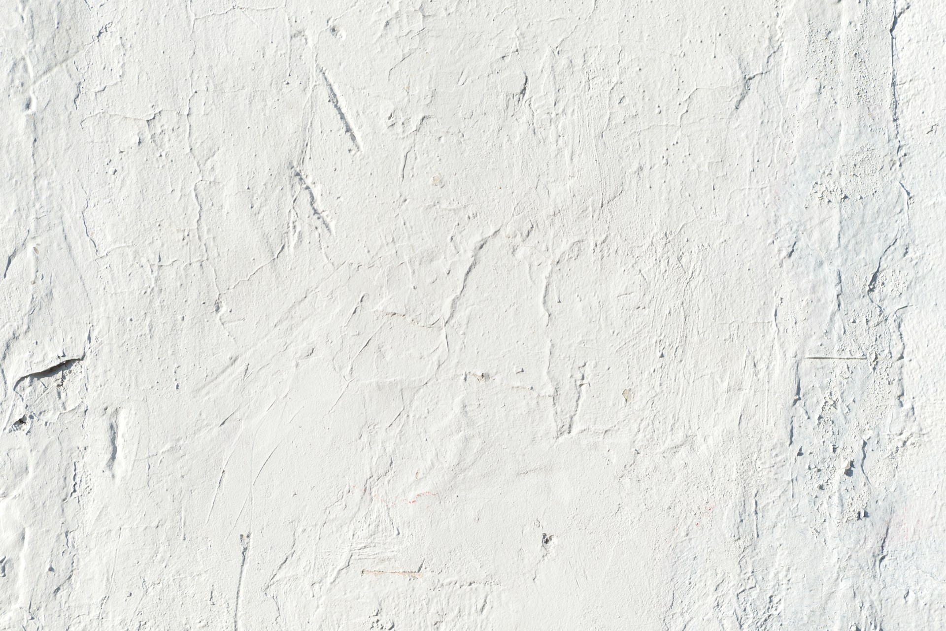 a white stucco wall with cracks in it