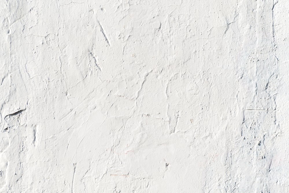 a white stucco wall with cracks in it