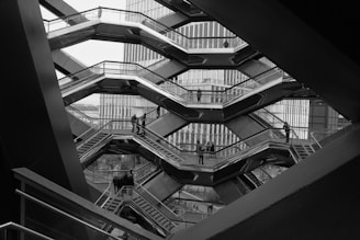 a black and white photo of a man on a escalator