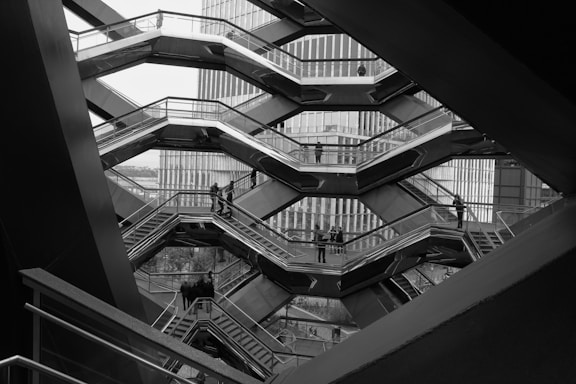 a black and white photo of a man on a escalator