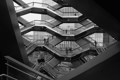 a black and white photo of a man on a escalator