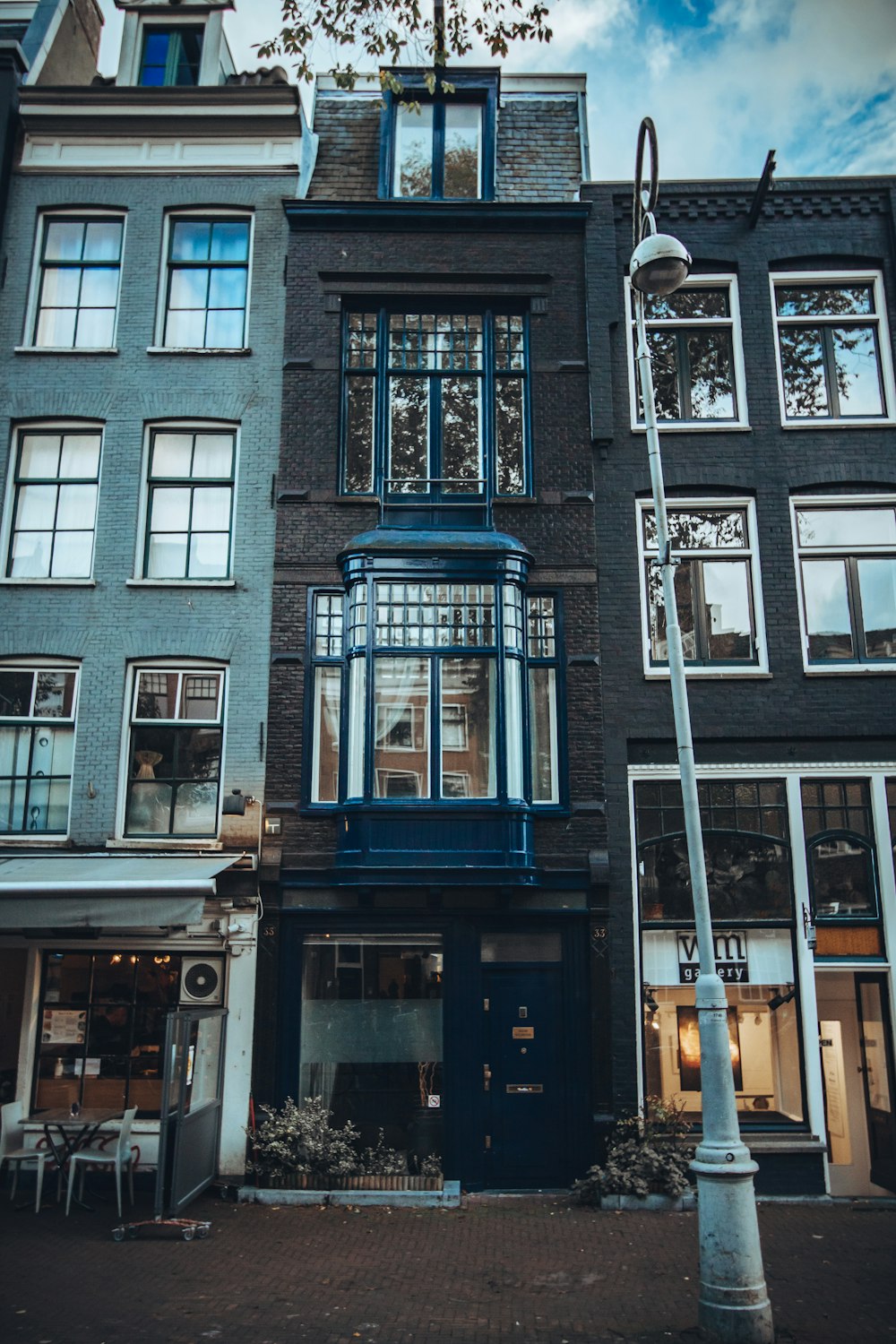 a tall blue building sitting next to a street light