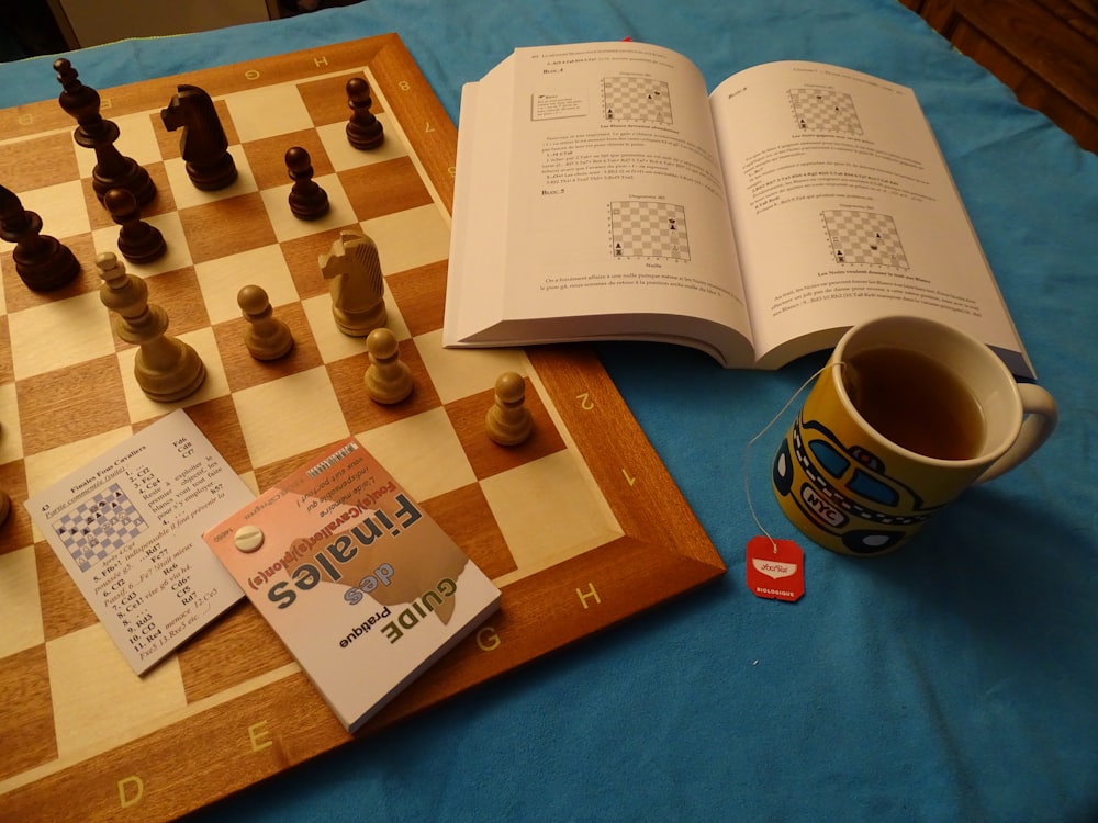 a chess game with a book and a cup of tea