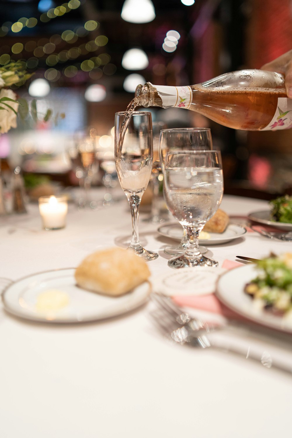 a person pours wine into a glass on a table