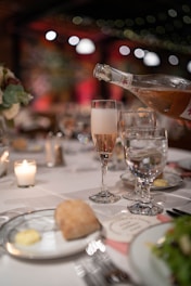 a table topped with plates of food and glasses of wine