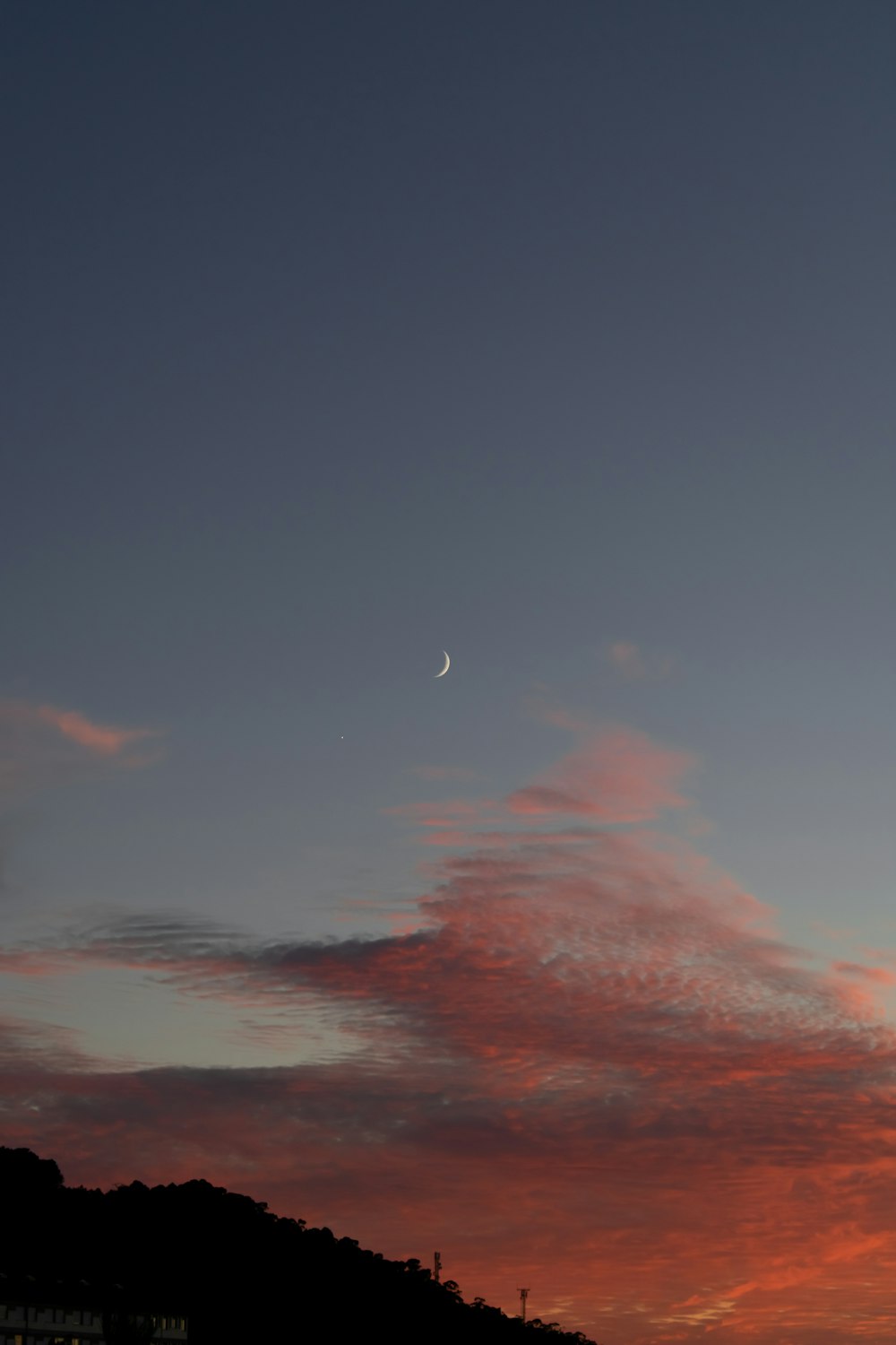 a plane flying in the sky at sunset