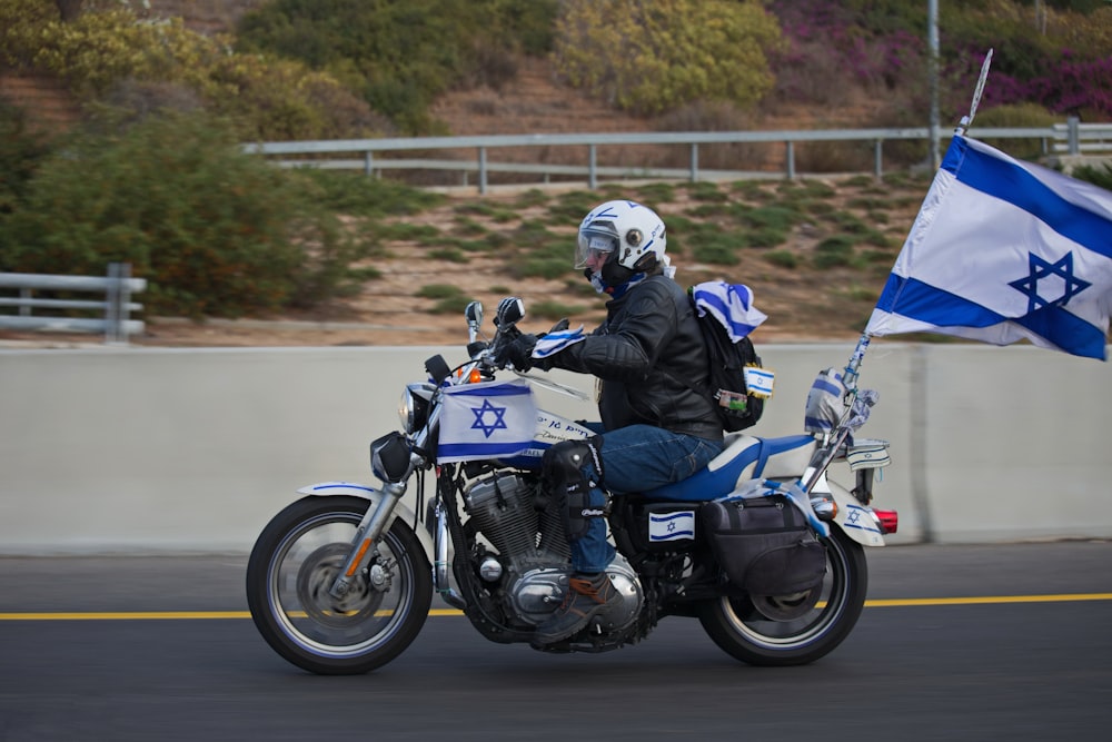 a man riding a motorcycle with a flag on the back of it