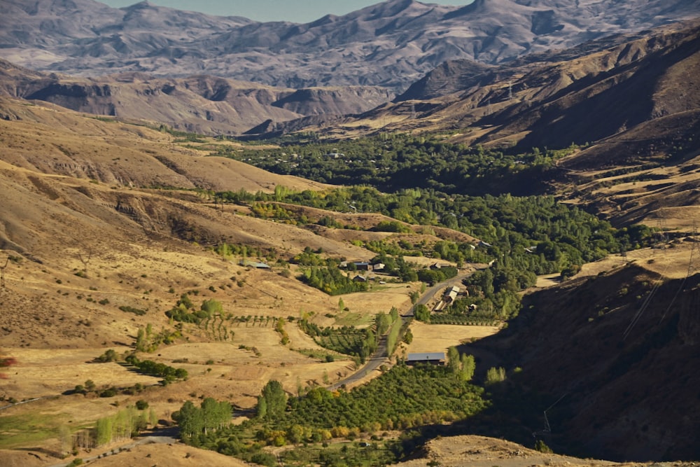 an aerial view of a valley with mountains in the background