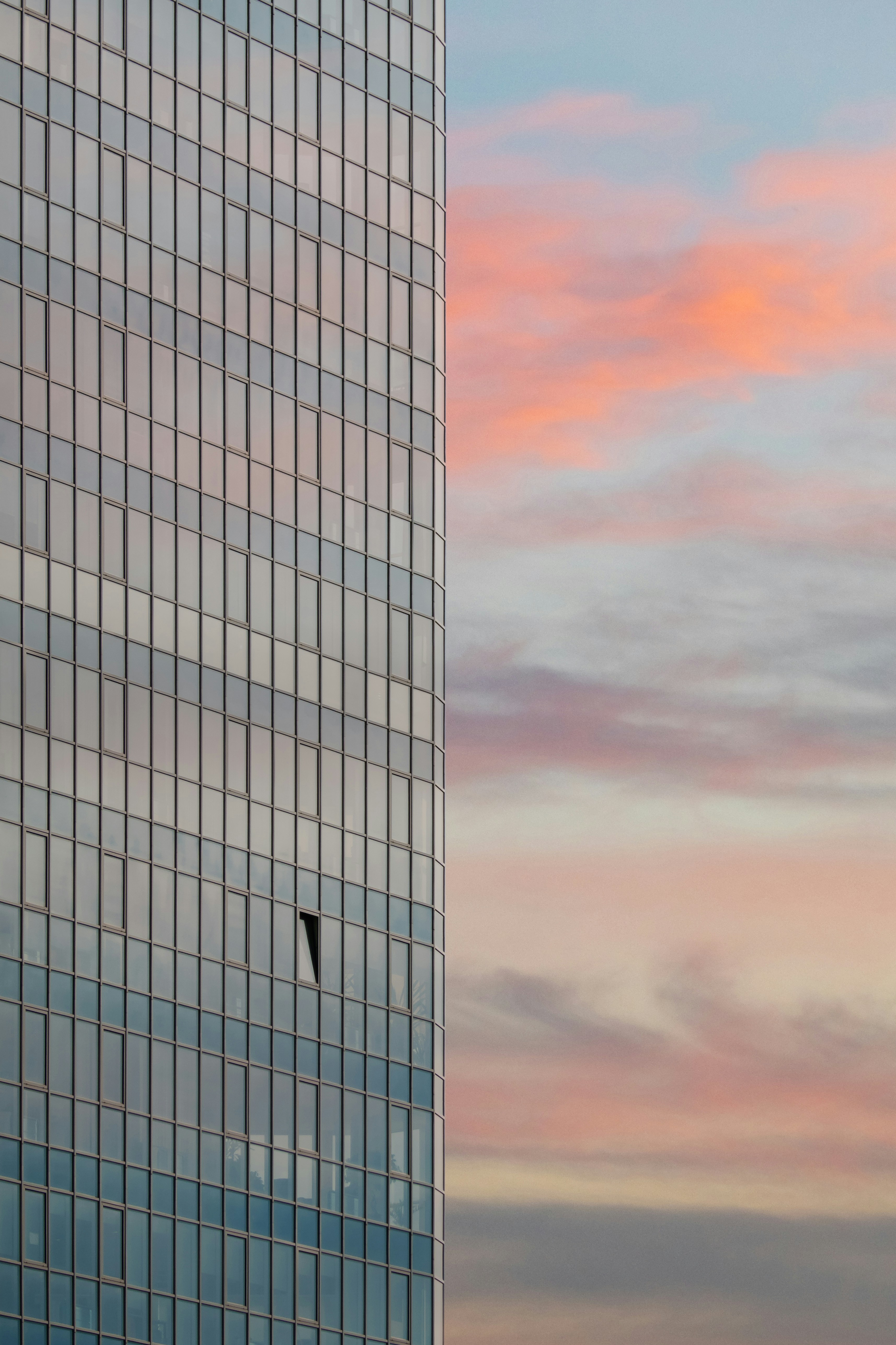 a plane flying in the sky next to a tall building