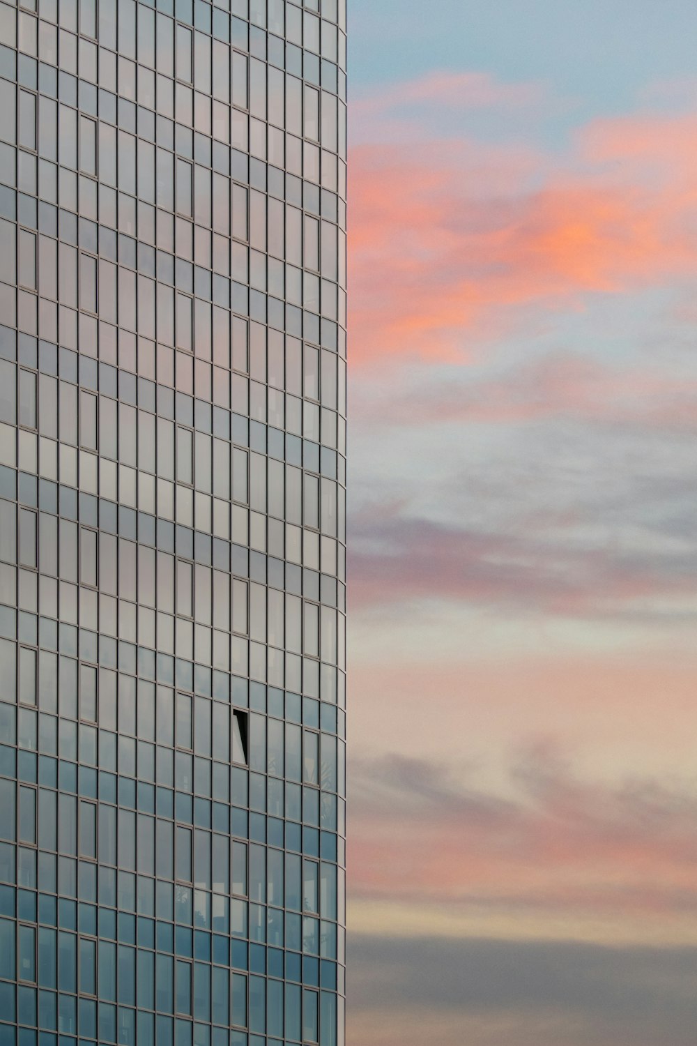 a plane flying in the sky next to a tall building