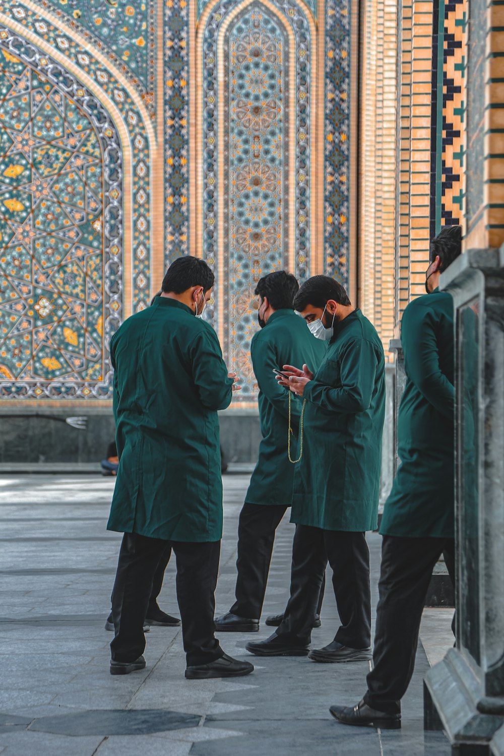 a group of men standing next to each other in front of a building