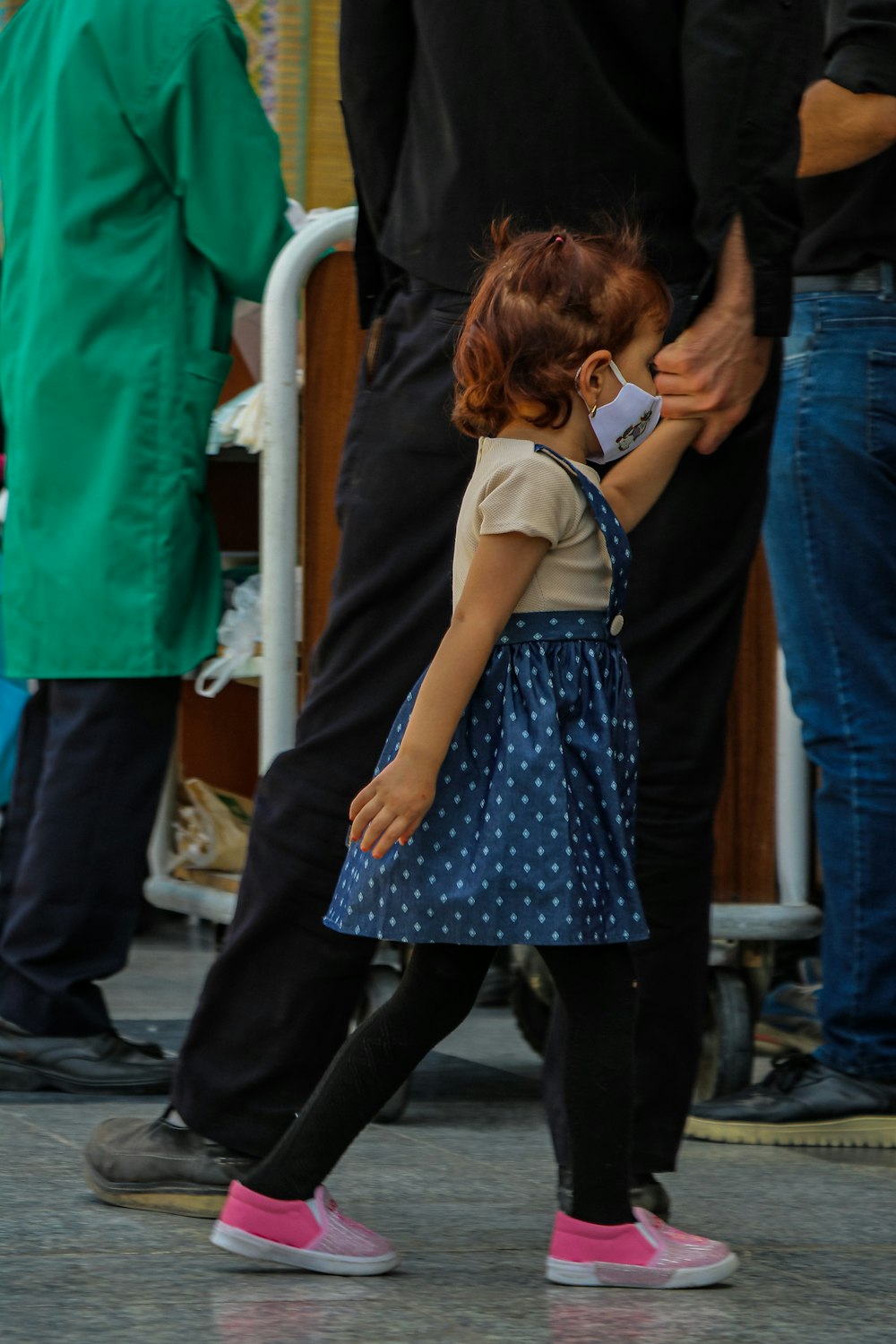 a little girl walking down a street next to a man