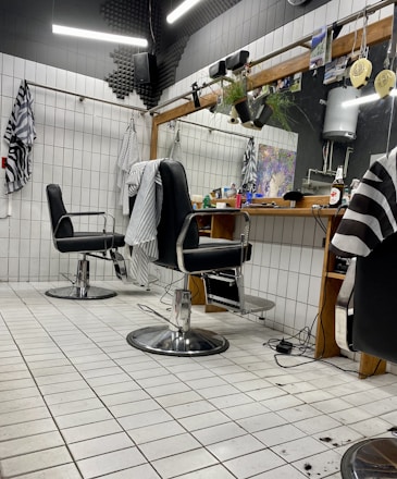 A stylish barber shop interior with chairs and grooming tools.