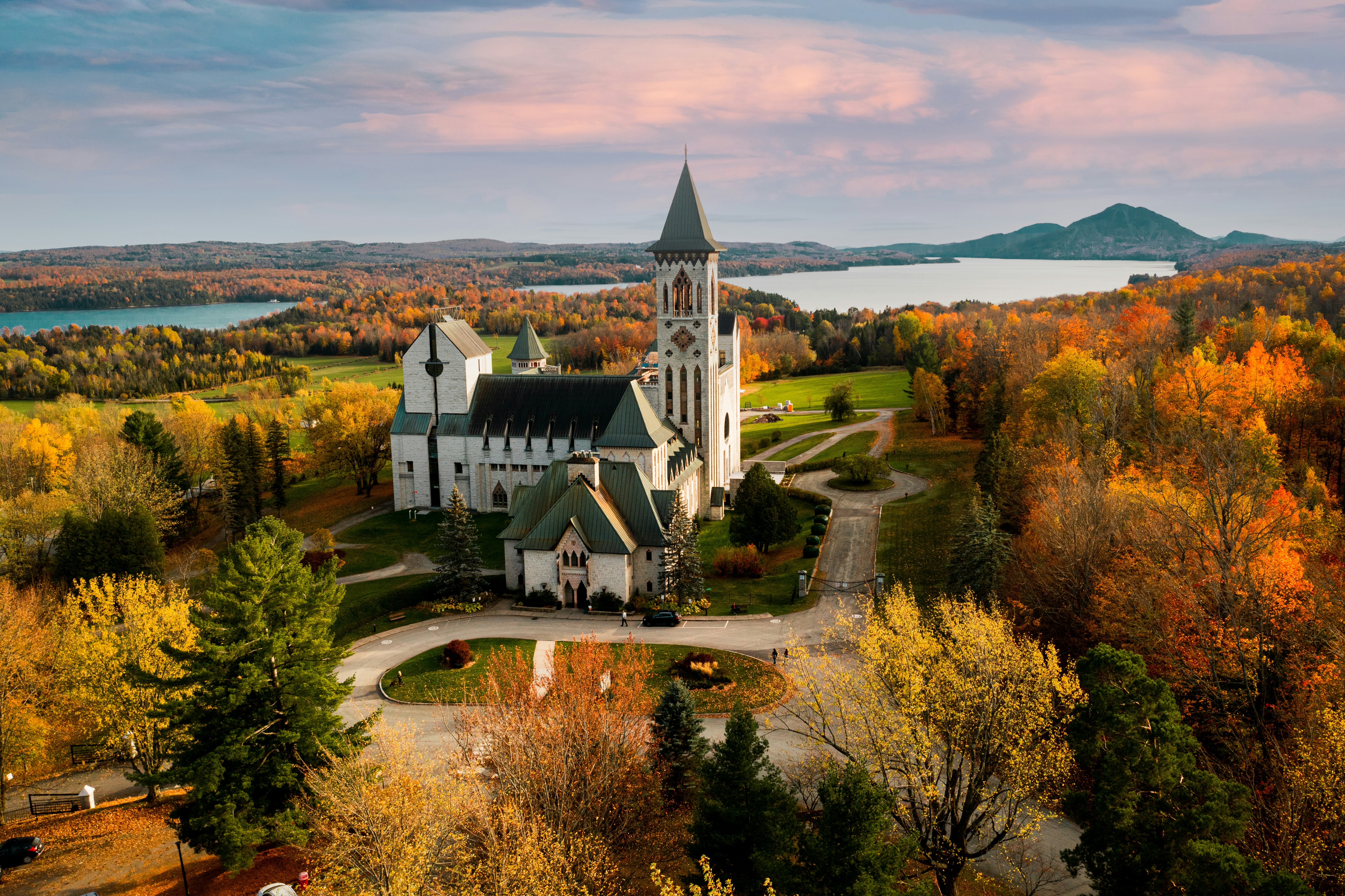 an aerial view of a church surrounded by trees