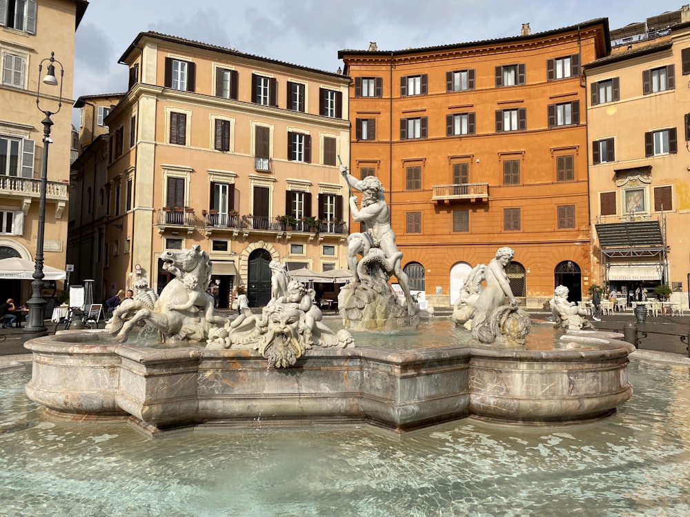 a fountain in front of a row of buildings