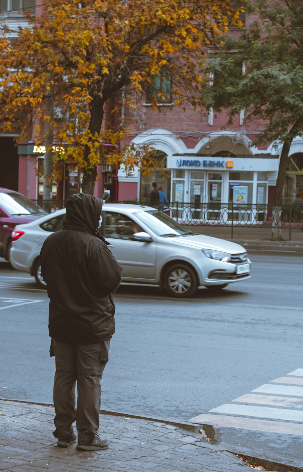 Un uomo in piedi sul ciglio di una strada vicino a un semaforo